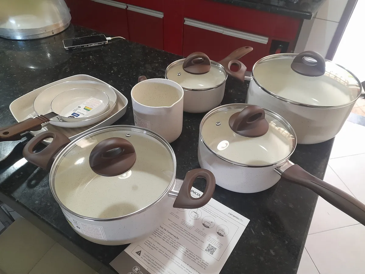 Foto enviada por cliente com as panelas e utensílios do conjunto sobre a bancada